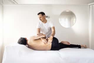 Physiotherapeut führt Manualtherapie an Patientin durch